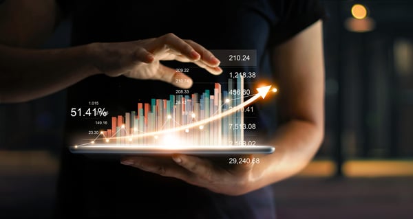 Hand carrying a tablet projecting 3d sales revenue in an increasing output
